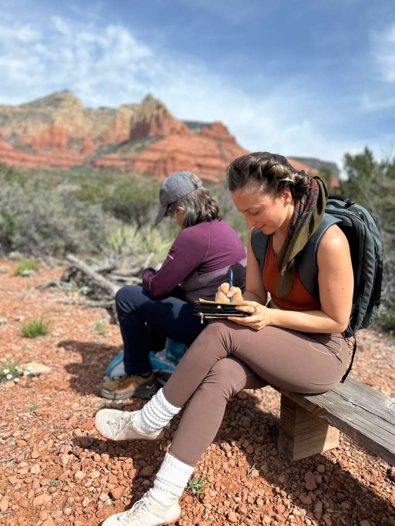 Guests journaling on the red rocks