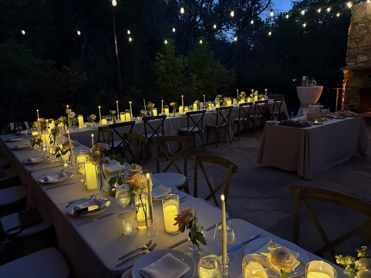 Candlelit long-table dinner under string lights at The Joy